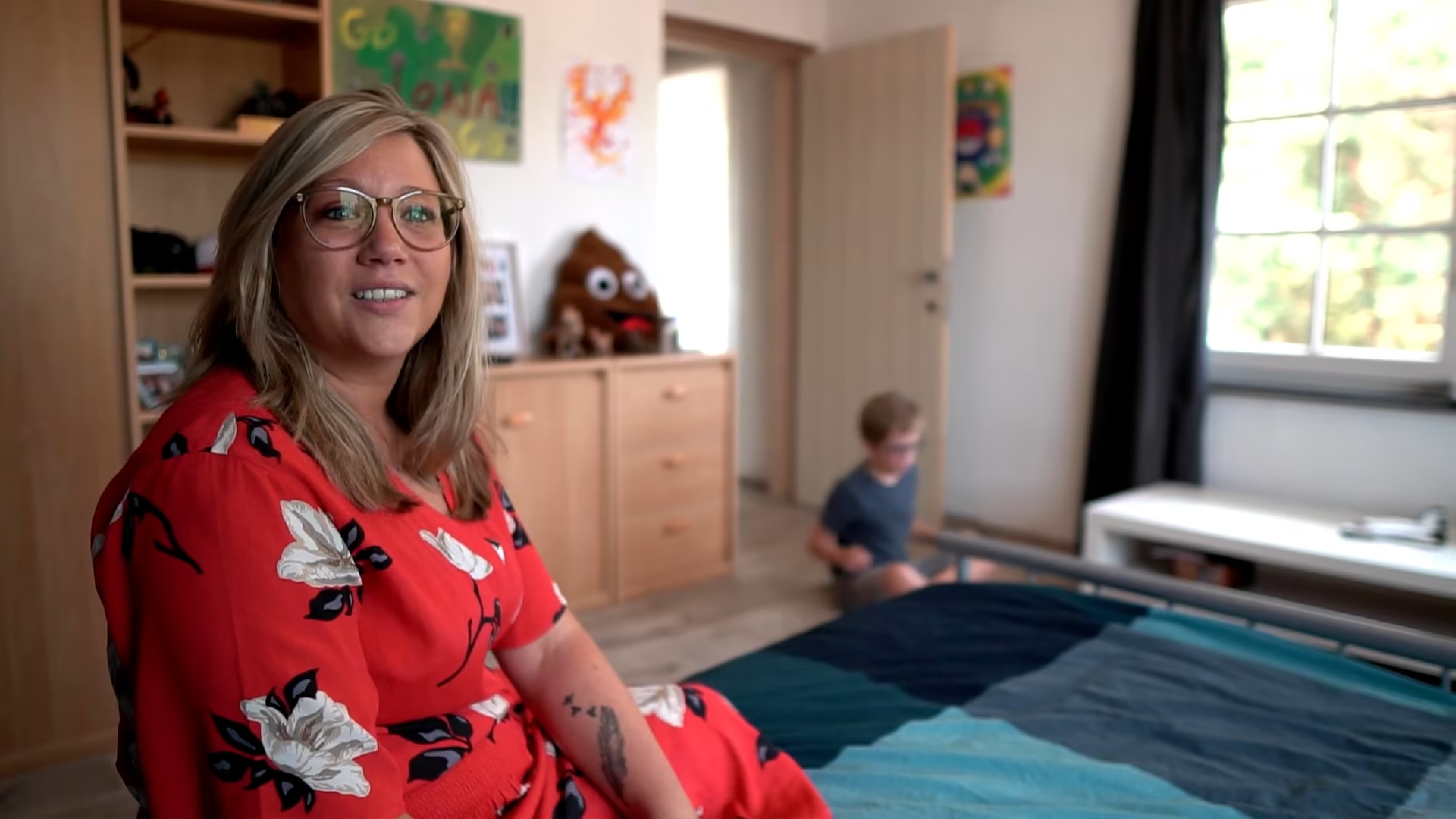 Een foto van Veronique tijdens de interview en haar zoon in de achtergrond